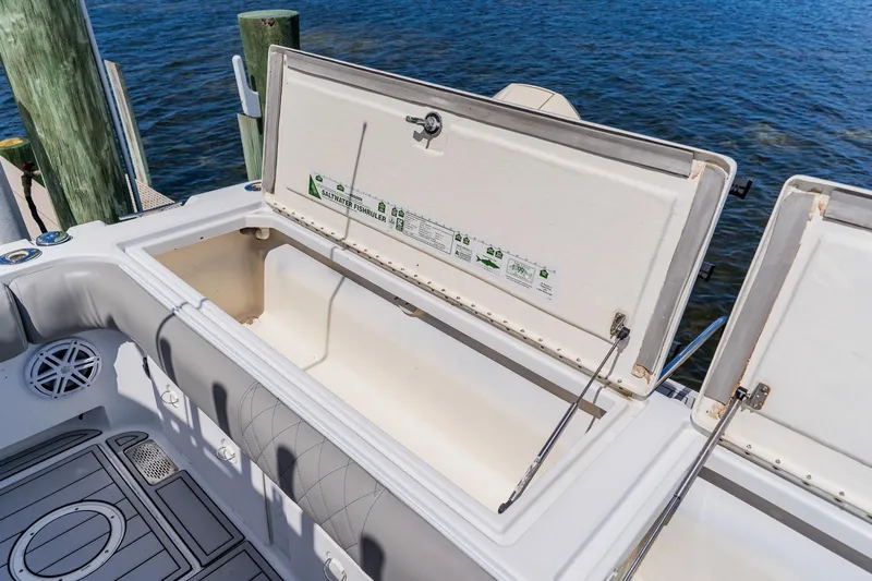 Slide: The Image of Open storage compartment on a 1998 World Cat 266 SF boat, docked by the water. - 40