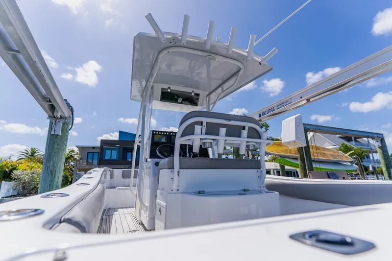 Slide: The Image of 1998 World Cat 266 SF boat interior with helm station, docked under clear blue sky. - 43