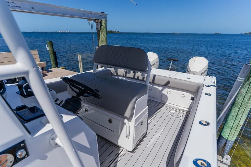 Slide: The Image of 1998 World Cat 266 SF boat interior with steering wheel, docked by the ocean. - 50