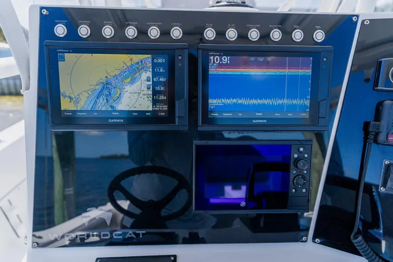 Slide: The Image of Control panel of a 1998 World Cat 266 SF boat with Garmin navigation displays. - 58