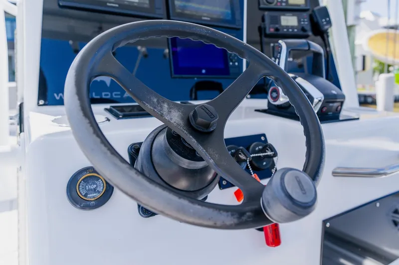 Slide: The Image of Steering wheel and controls of a 1998 World Cat 266 SF boat. - 60