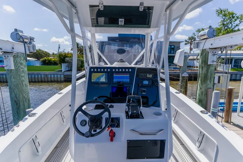 Slide: The Image of 1998 World Cat 266 SF boat cockpit with steering wheel and navigation equipment. - 64