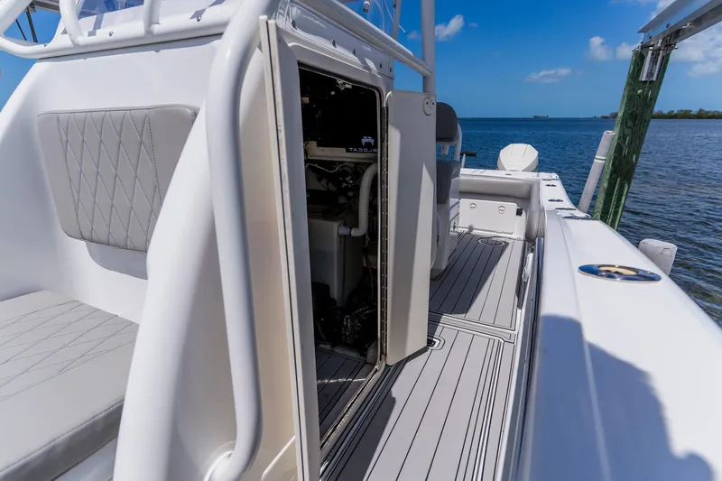 Slide: The Image of 1998 World Cat 266 SF boat interior with open hatch, docked by the water. - 67