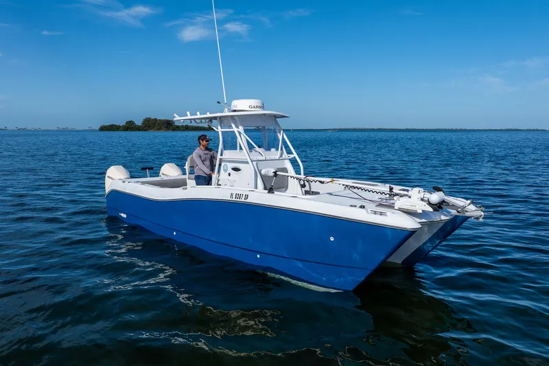 Slide: The Image of A 1998 World Cat 266 SF boat on calm blue waters under a clear sky. - 7