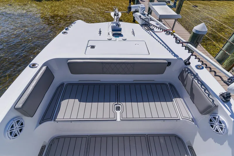 Slide: The Image of 1998 World Cat 266 SF boat deck with seating and storage, docked by clear water. - 81