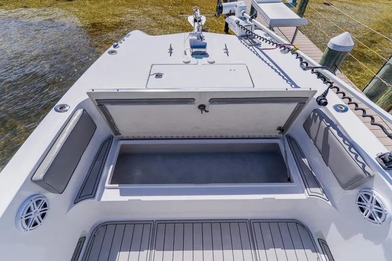 Slide: The Image of 1998 World Cat 266 SF boat with open storage compartment, docked by clear water. - 87