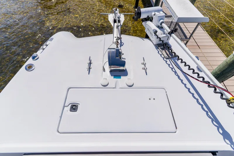 Slide: The Image of 1998 World Cat 266 SF boat deck with anchor and motor, docked by clear water. - 88