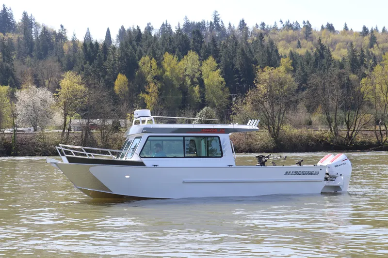 The Image of 2026 Alumaweld Horizon 26 boat cruising on a river with forested background. - 0
