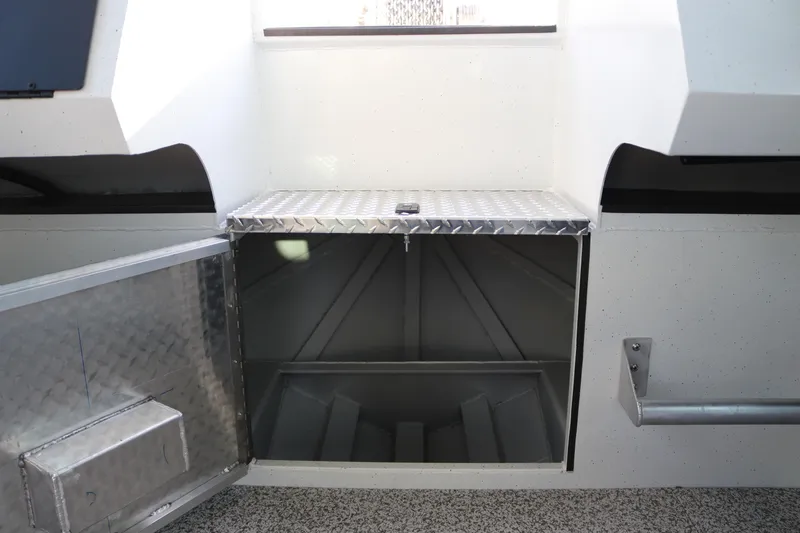 Slide: The Image of Storage compartment in 2026 Alumaweld Horizon 26 boat, featuring diamond plate door and spacious interior. - 13