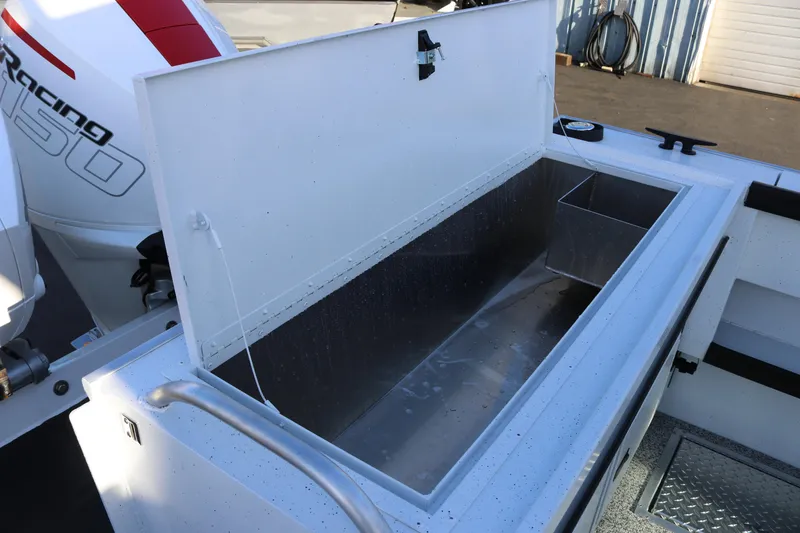 Slide: The Image of Open storage compartment on 2026 Alumaweld Horizon 26 boat, featuring a powerful engine. - 19
