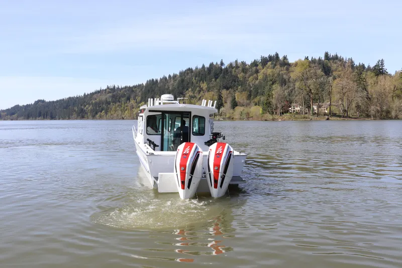 Slide: The Image of 2026 Alumaweld Horizon 26 boat cruising on a scenic lake with forested hills. - 3