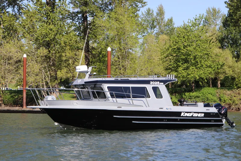 The Image of 2026 KingFisher 3025 XRS boat on a river, surrounded by lush greenery. - 0