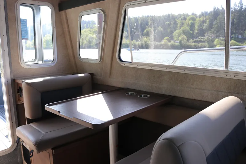 Slide: The Image of Interior of 2026 KingFisher 3025 XRS boat with seating and table, scenic water view. - 11