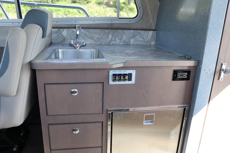 Slide: The Image of Interior of 2026 KingFisher 3025 XRS boat with sink, counter, and storage drawers. - 13