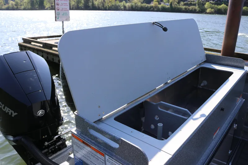 Slide: The Image of Open storage compartment on 2026 KingFisher 3025 XRS boat by the water. - 17