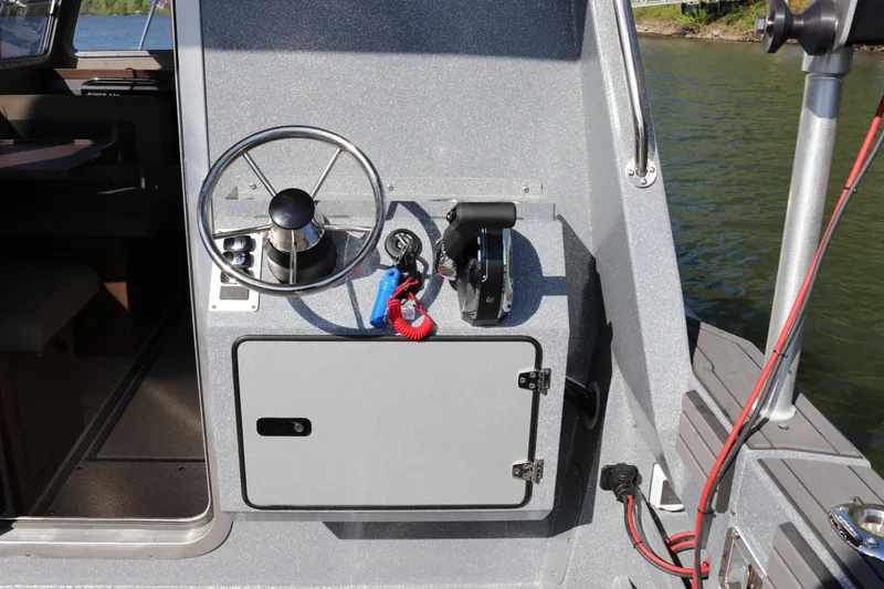 Slide: The Image of Steering console of 2026 KingFisher 3025 XRS boat, featuring wheel and throttle controls. - 20