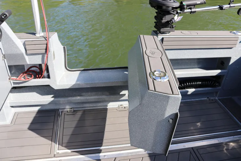 Slide: The Image of 2026 KingFisher 3025 XRS boat interior with storage compartments and motor, on calm water. - 23