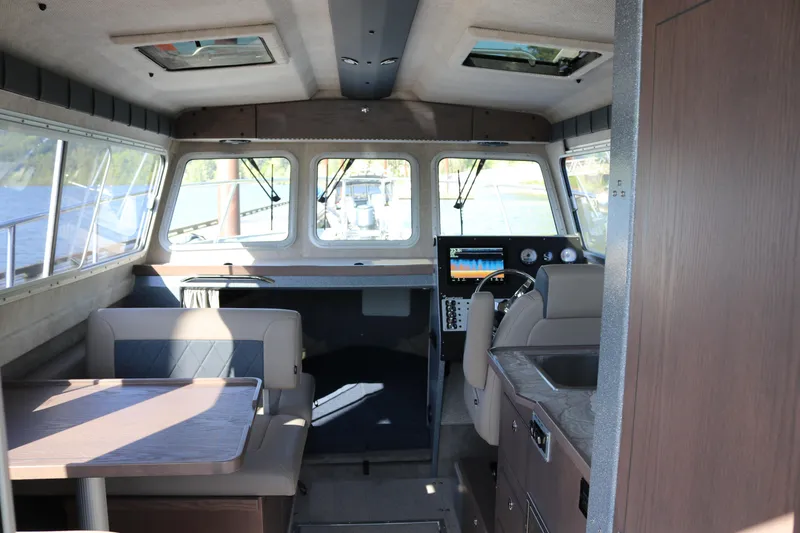 Slide: The Image of Interior of 2026 KingFisher 3025 XRS boat with seating, table, and navigation controls. - 4