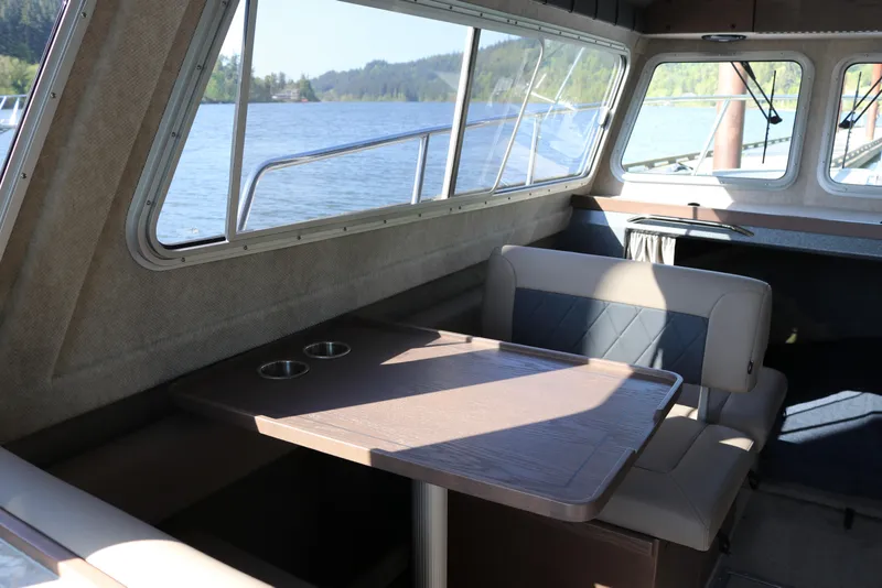Slide: The Image of Interior of 2026 KingFisher 3025 XRS boat with seating and table, overlooking scenic lake. - 9