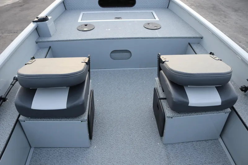 Slide: The Image of 2026 Smoker Craft Sportsman 1660 boat interior with dual cushioned seats and storage compartments. - 12