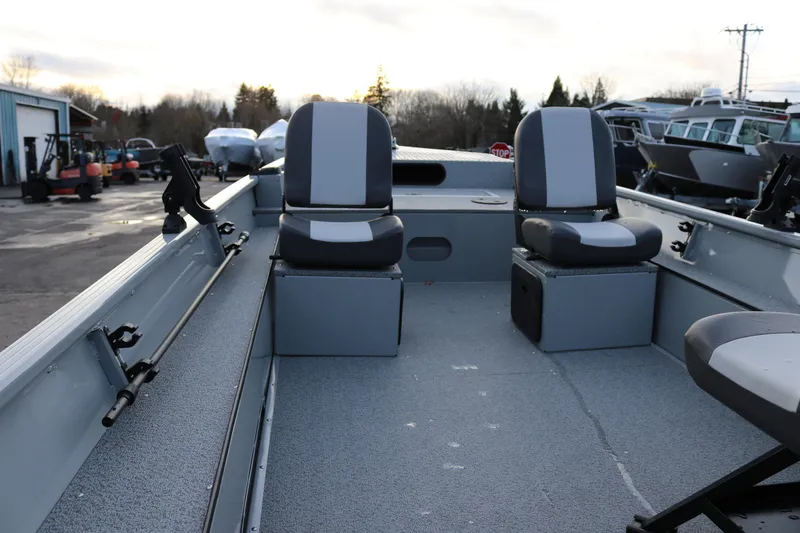 Slide: The Image of 2026 Smoker Craft Sportsman 1660 boat interior with dual seats and fishing rod holders. - 5