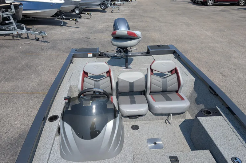 Slide: The Image of 2022 G3 Sportsman 1710 boat interior with seating and steering wheel, parked outdoors. - 3