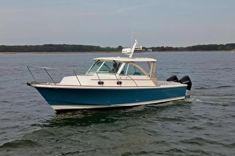 Slide: The Image of 2020 Hunt Yachts Surfhunter 32 cruising on calm waters, showcasing sleek design and twin engines. - 30