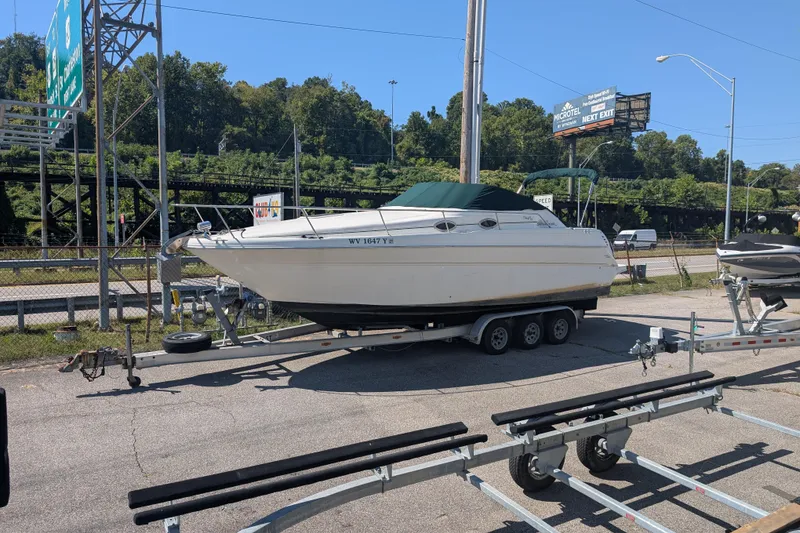 The Image of 1999 Sea Ray 270 Sundancer Special Edition boat on trailer in parking lot. - 0