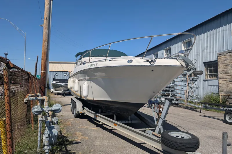 Slide: The Image of 1999 Sea Ray 270 Sundancer Special Edition boat on trailer, parked outdoors. - 2