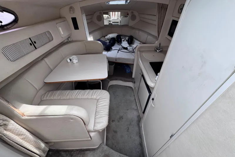 Slide: The Image of Interior of 1999 Sea Ray 270 Sundancer Special Edition boat, featuring seating and kitchenette. - 9