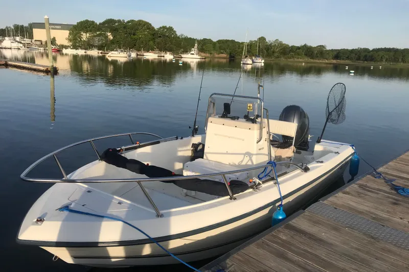 Slide: The Image of 2003 Sea Boss 190 Center Console boat docked at marina during sunset. - 2