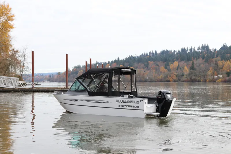 Slide: The Image of 2026 Alumaweld Stryker 202 boat on a calm lake with autumn trees in the background. - 3