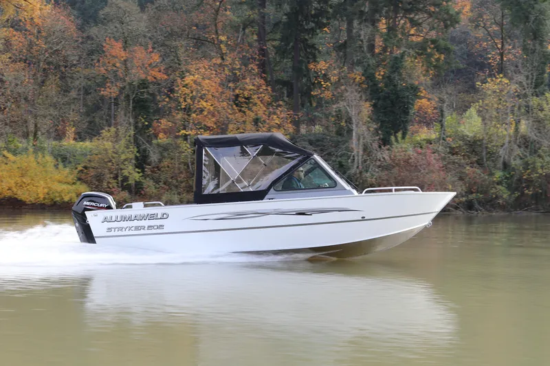Slide: The Image of 2026 Alumaweld Stryker 202 boat cruising on a river with autumn foliage backdrop. - 4