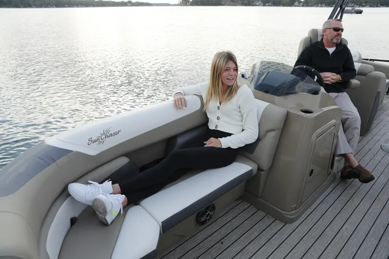 Slide: The Image of 2026 SunChaser Eclipse 25 LR DH pontoon boat with passengers enjoying a serene lake view. - 5