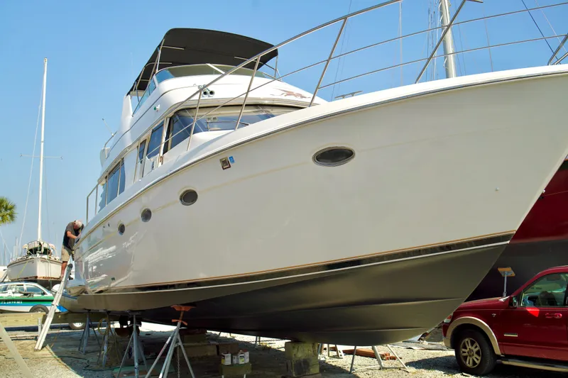 Slide: The Image of 1999 Carver 450 Voyager Pilothouse yacht on dry dock with maintenance work underway. - 13