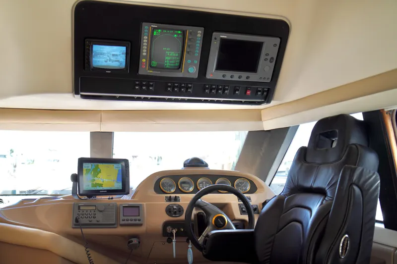 Slide: The Image of Interior of a 1999 Carver 450 Voyager Pilothouse with navigation equipment and captain's chair. - 21