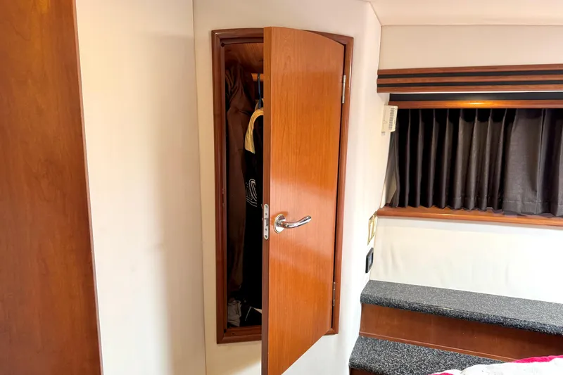 Slide: The Image of Interior of 1999 Carver 450 Voyager Pilothouse with open wooden closet and window. - 39