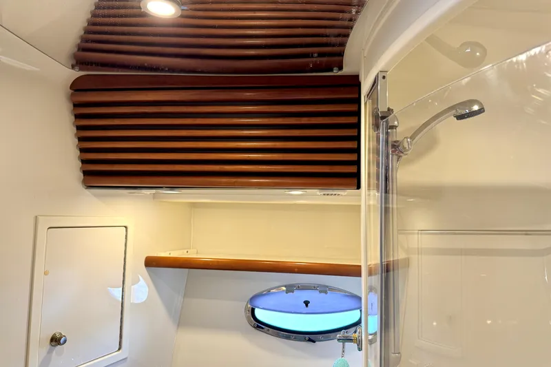Slide: The Image of 1999 Carver 450 Voyager Pilothouse bathroom with shower and wooden accents. - 41