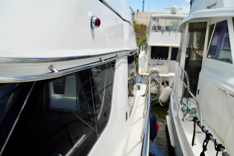 Slide: The Image of 1999 Carver 450 Voyager Pilothouse yacht docked alongside another boat. - 5