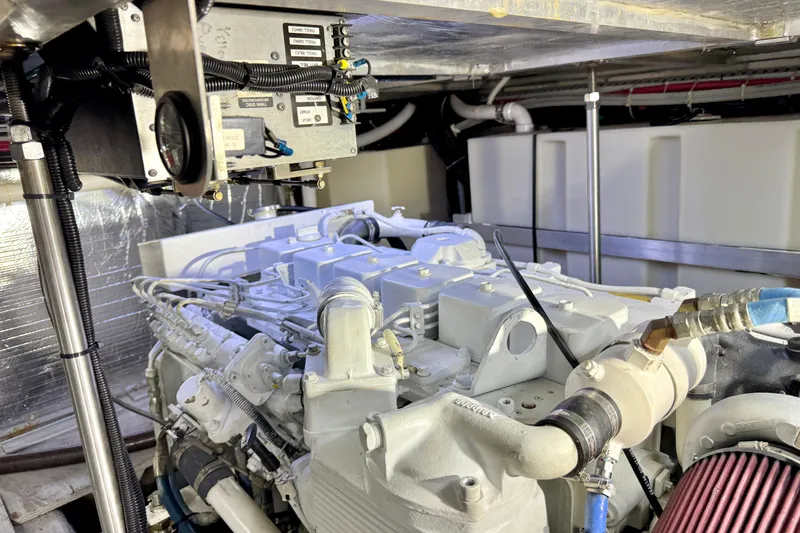 Slide: The Image of Engine room of 1999 Carver 450 Voyager Pilothouse, showcasing mechanical components and wiring. - 51