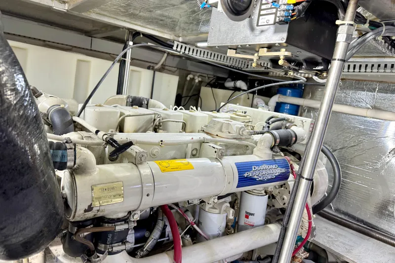 Slide: The Image of Engine room of a 1999 Carver 450 Voyager Pilothouse yacht, showcasing mechanical components. - 54