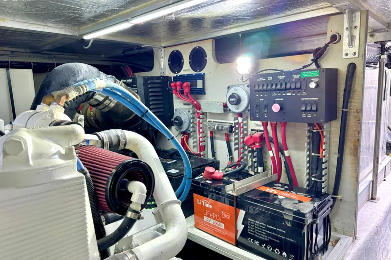Slide: The Image of Engine room of a 1999 Carver 450 Voyager Pilothouse with electrical components and batteries. - 56