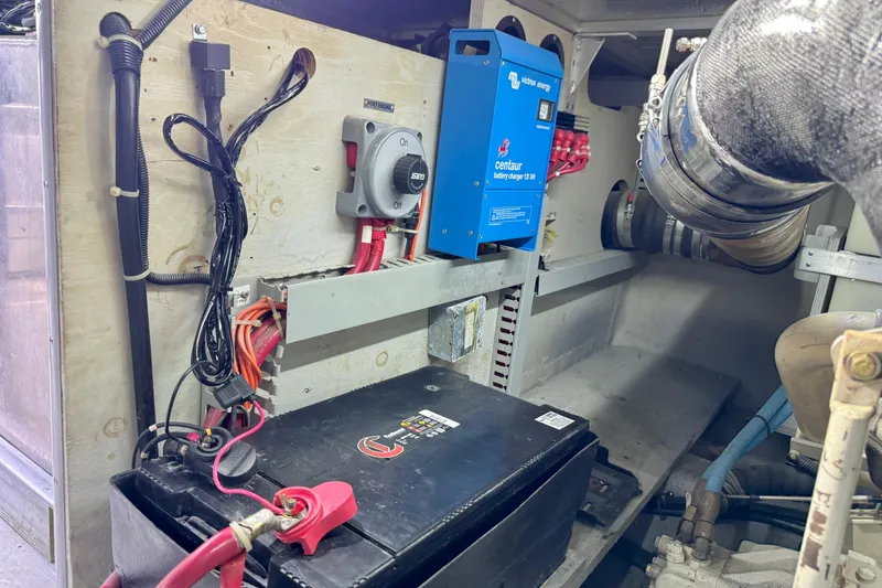 Slide: The Image of Engine room of 1999 Carver 450 Voyager Pilothouse with battery and charger setup. - 57