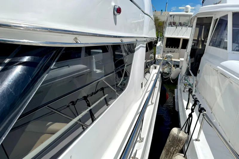 Slide: The Image of 1999 Carver 450 Voyager Pilothouse yacht docked alongside another boat. - 6