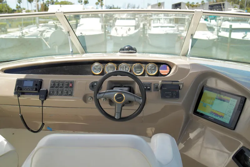 Slide: The Image of 1999 Carver 450 Voyager Pilothouse helm with steering wheel, gauges, and navigation equipment. - 67