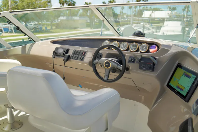 Slide: The Image of 1999 Carver 450 Voyager Pilothouse helm with steering wheel, gauges, and navigation equipment. - 68