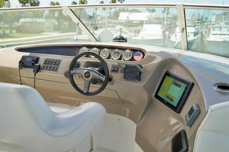 Slide: The Image of 1999 Carver 450 Voyager Pilothouse helm with steering wheel, gauges, and navigation display. - 69