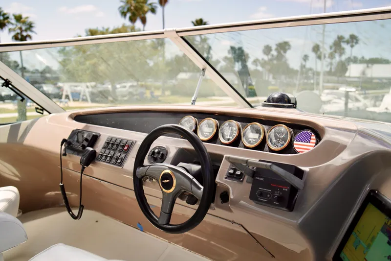 Slide: The Image of 1999 Carver 450 Voyager Pilothouse helm with steering wheel, gauges, and communication equipment. - 70