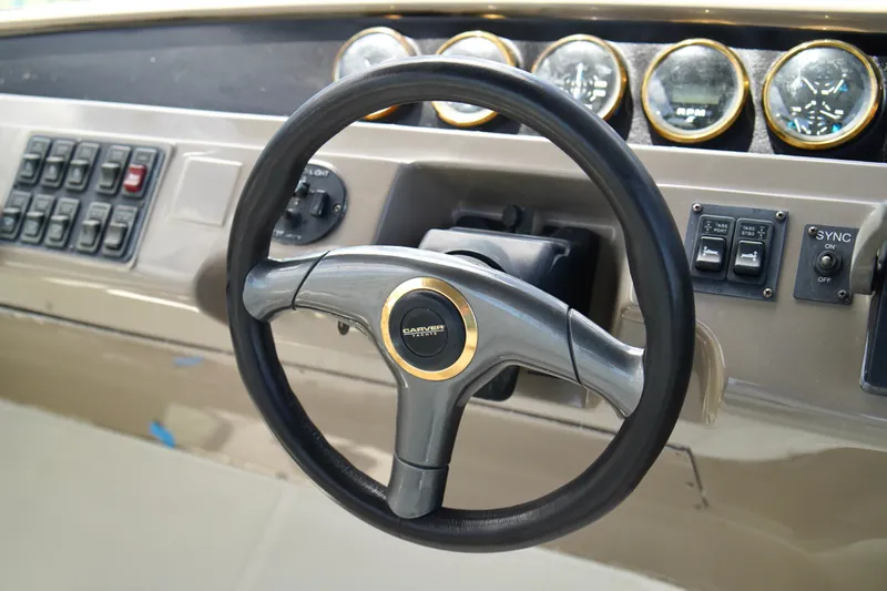 Slide: The Image of 1999 Carver 450 Voyager Pilothouse steering wheel and dashboard controls. - 71