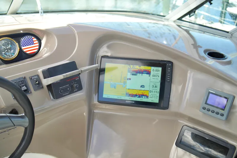 Slide: The Image of 1999 Carver 450 Voyager Pilothouse dashboard with Garmin navigation display and American flag emblem. - 74